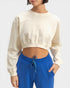 Person wearing a cream sweatshirt and blue pants on a white background