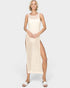 Woman wearing a beige crochet dress with a slit on a white background