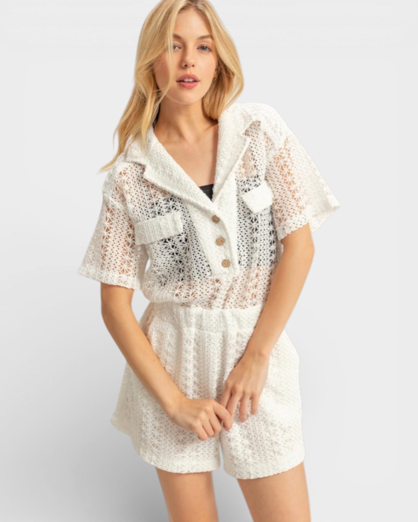 Woman wearing a white lace outfit on a plain background