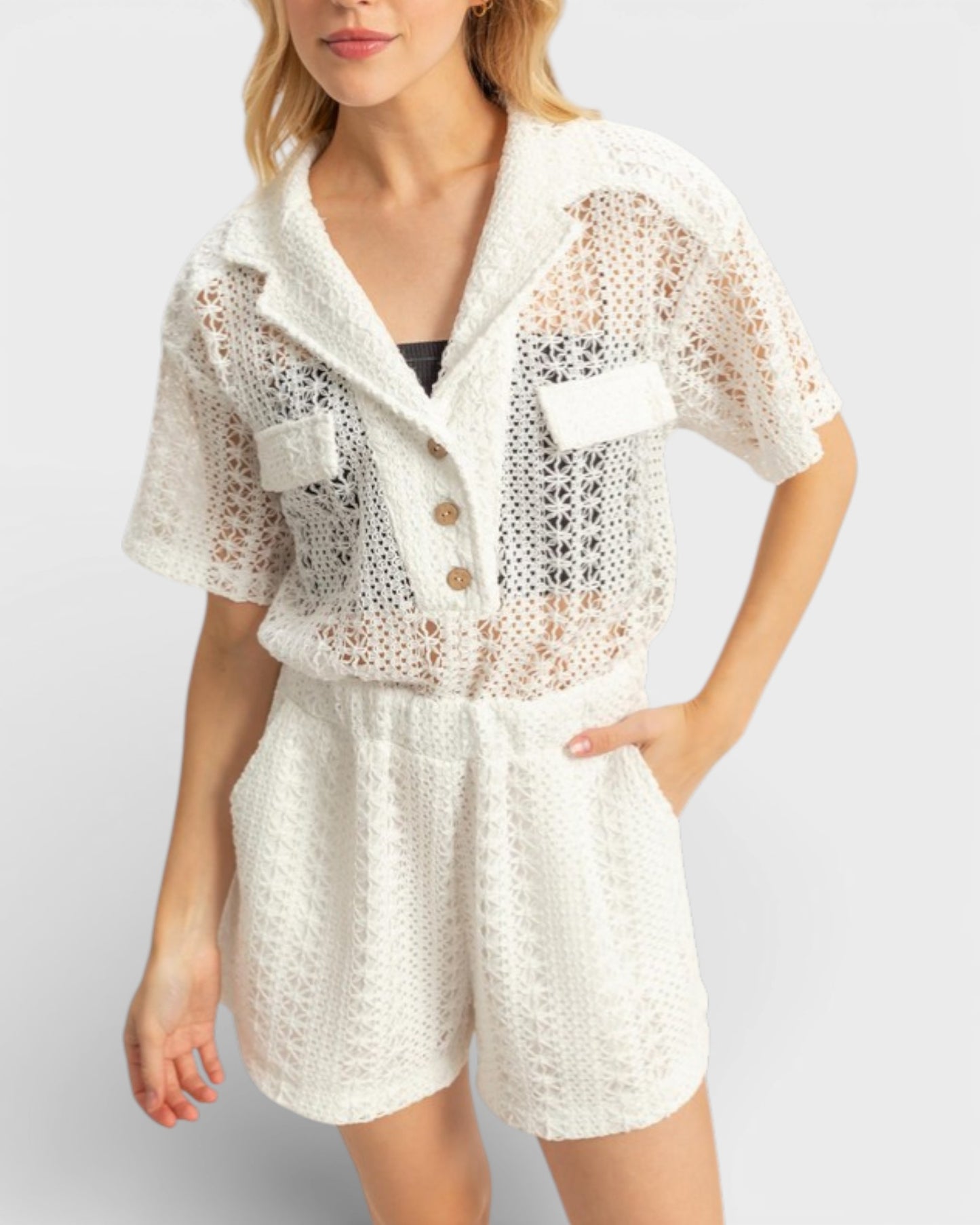 Woman wearing a white lace outfit with a plain background