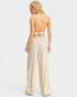 Woman wearing a beige jumpsuit with thin straps on a white background