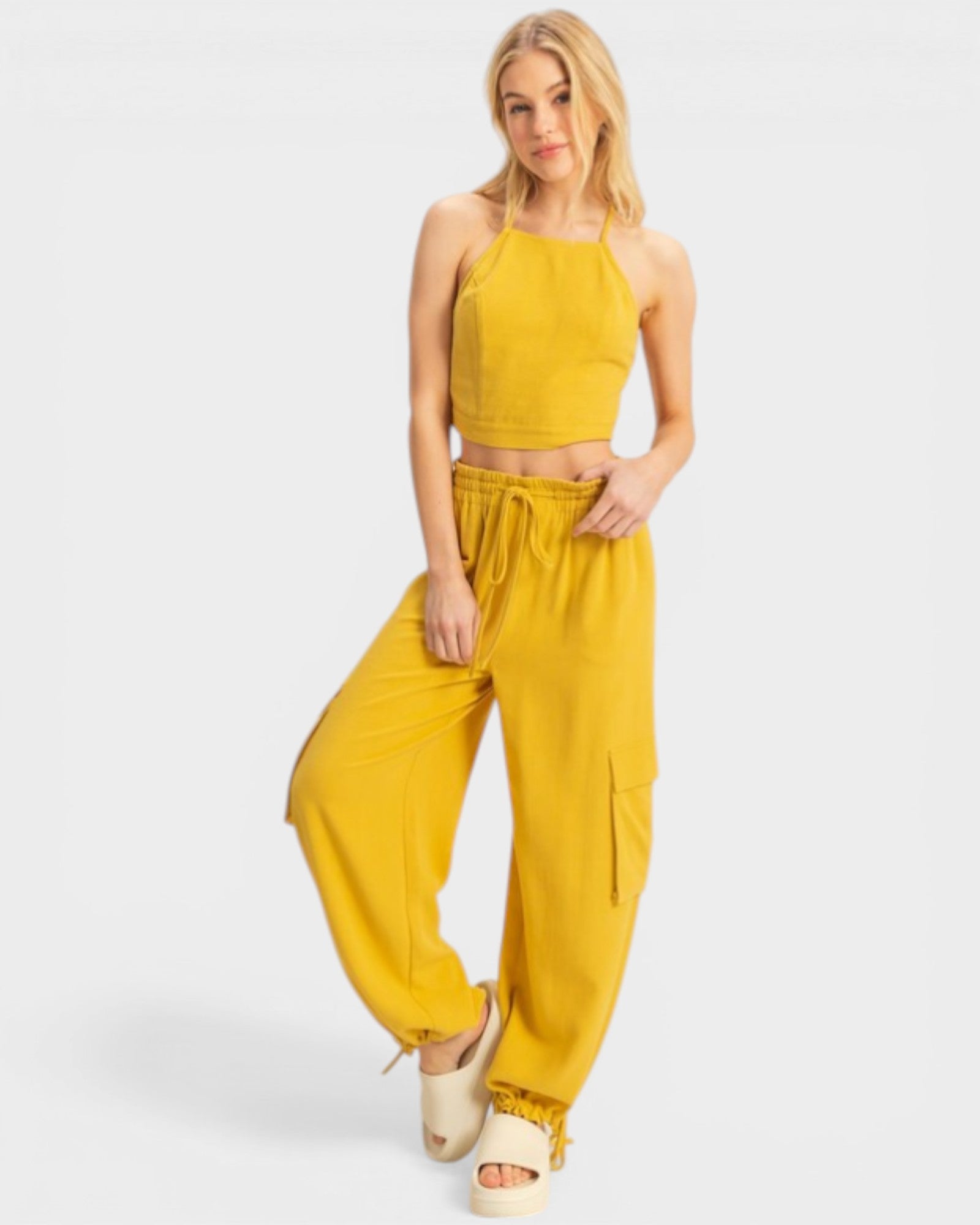 Woman wearing a mustard yellow outfit on a white background