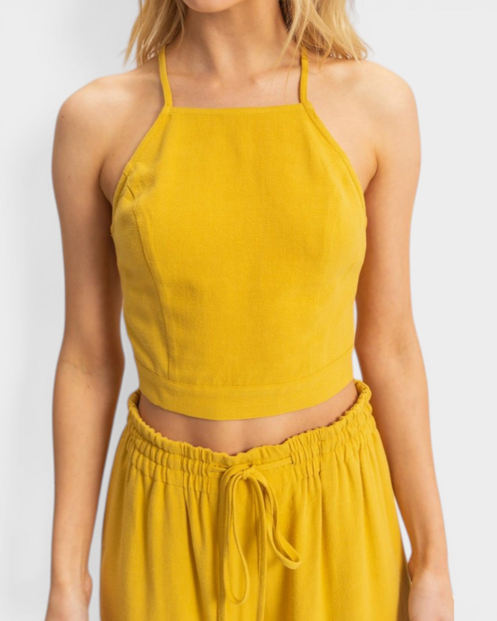 Yellow sleeveless top and pants set on a white background