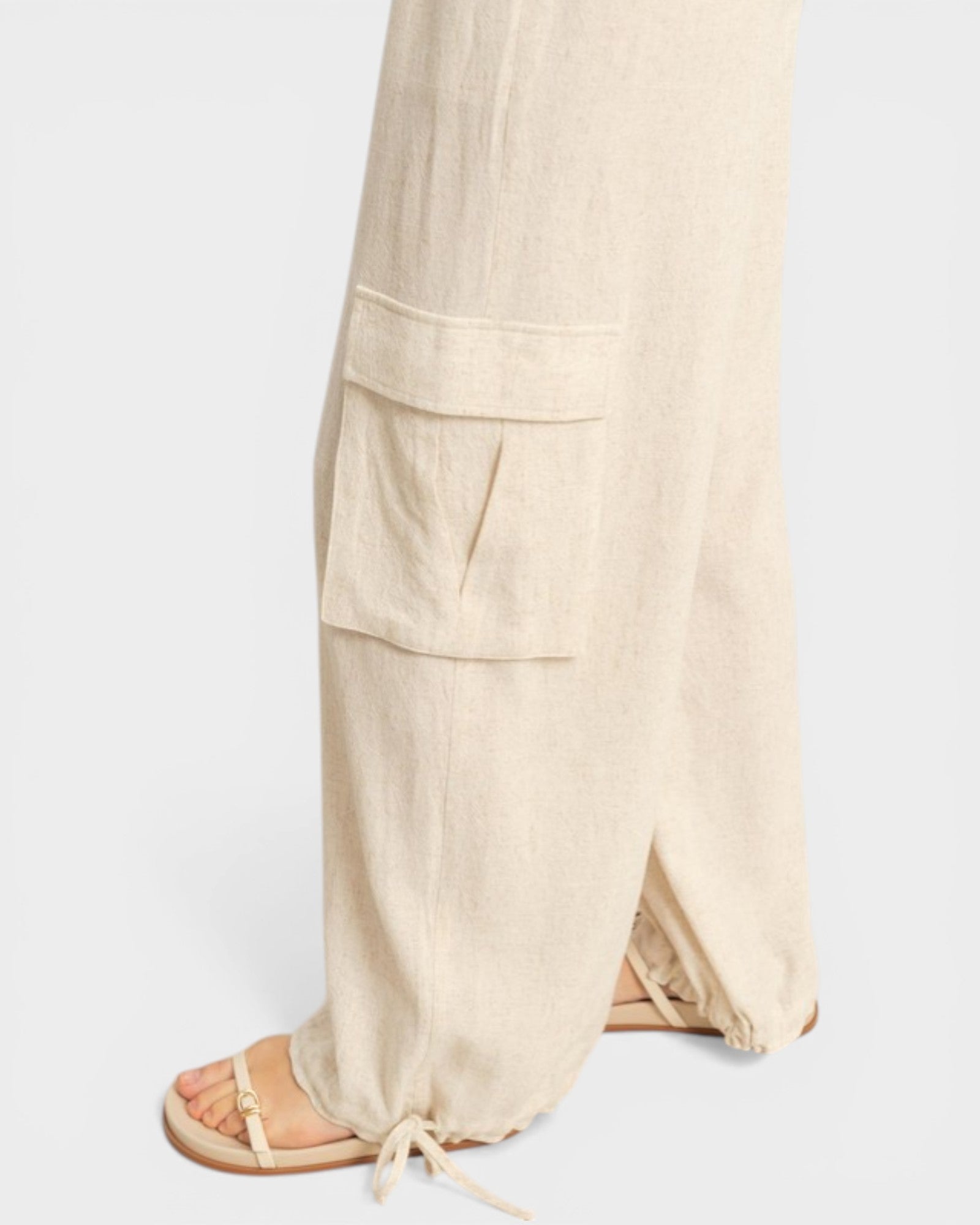 Beige linen pants with drawstring on a white background