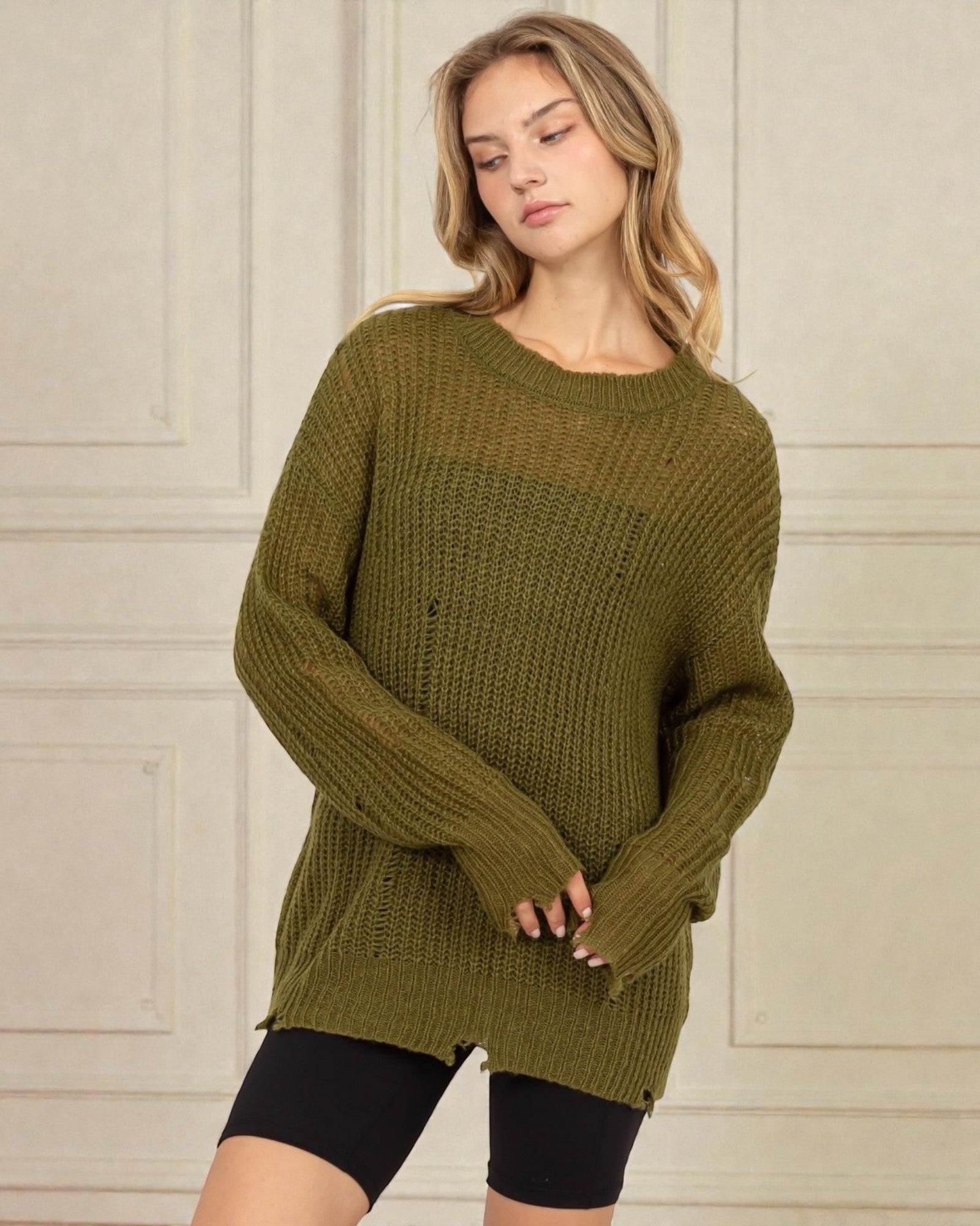 Woman wearing a green sweater against a neutral background