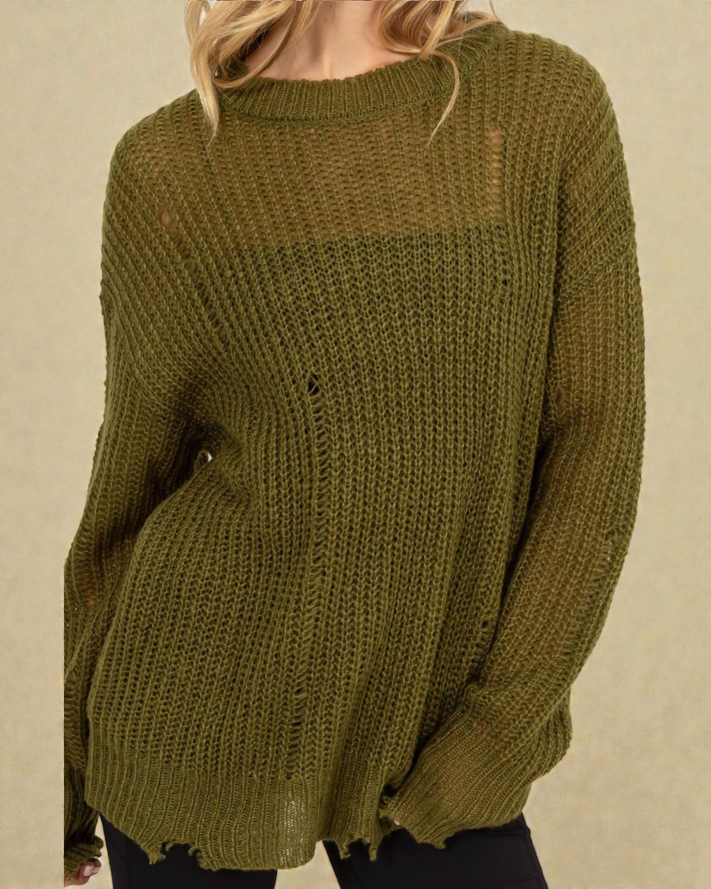 Green knitted sweater worn by a person on a beige background