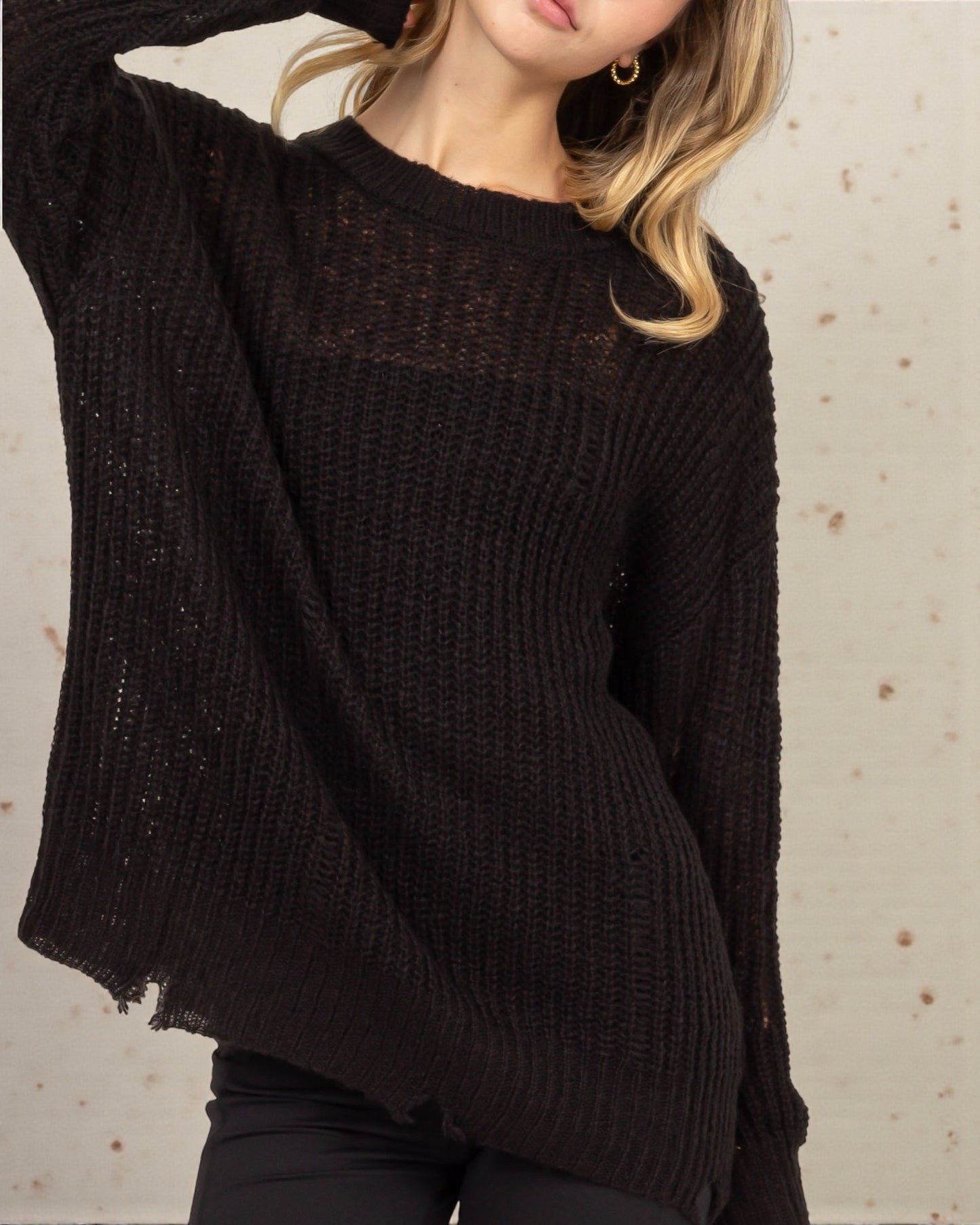 Person wearing a dark brown sweater against a neutral background
