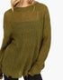 An olive green chunky knit sweater with distressed details, worn by a model against a plain white background.