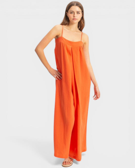 Woman wearing an orange slip dress on a white background