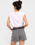 A woman shown from the back wearing a light lavender sleeveless top and gray-and-white pinstriped shorts with a black belt, against a light gray studio background.