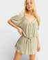 Woman wearing a light green romper on a white background