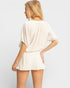 Woman wearing a white outfit on a plain background