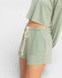 Person wearing green shorts with a drawstring on a white background