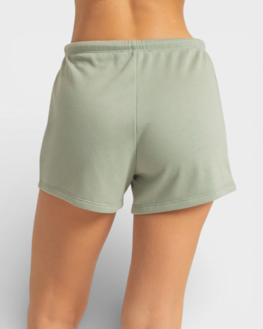 Green shorts worn by a person on a white background