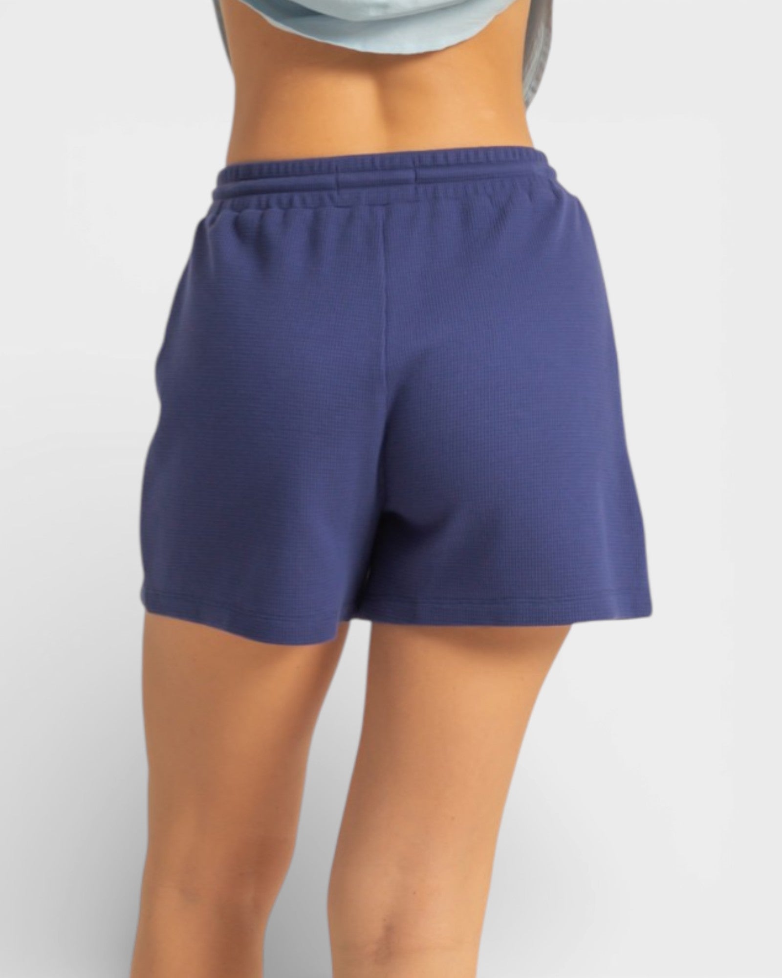 Person wearing blue shorts on a white background