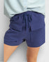 Navy blue shorts with pockets and drawstring on a light gray background