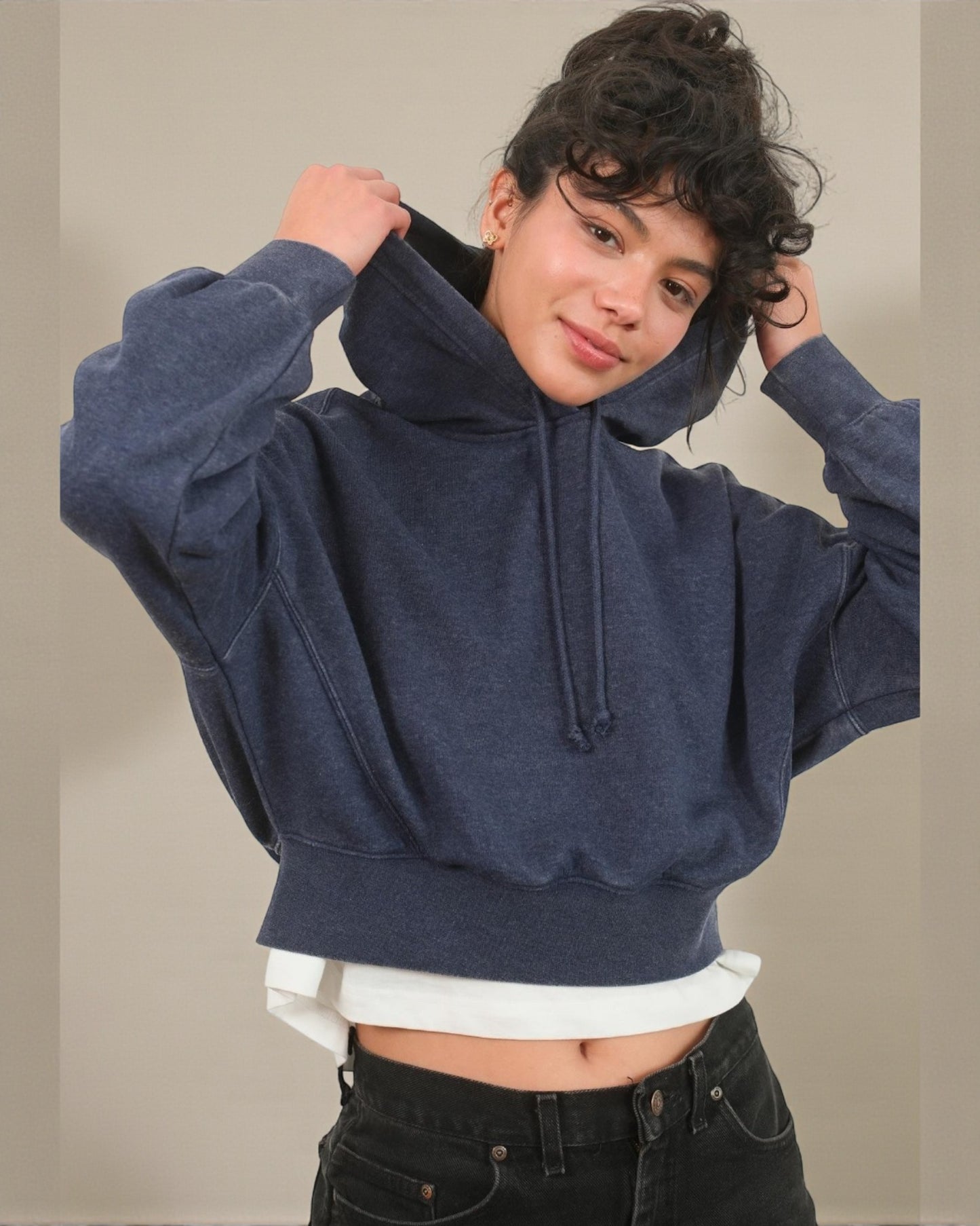 Person wearing a navy blue hoodie with a plain background