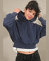 Person wearing a navy blue hoodie with a plain background