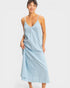 Woman wearing a light blue slip dress on a white background
