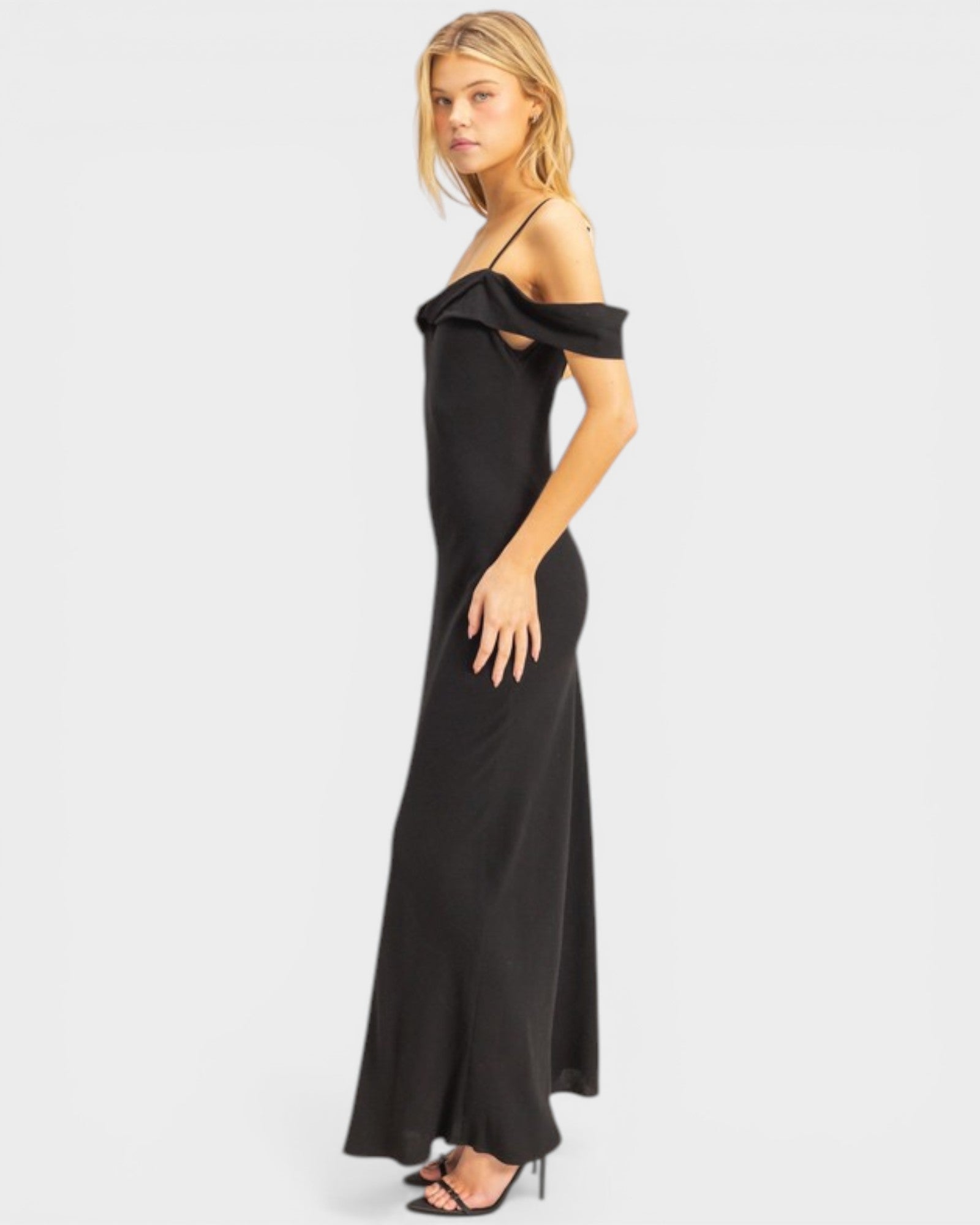 Woman wearing a black off-shoulder evening gown on a white background