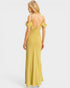 Woman wearing a yellow dress with thin straps on a white background