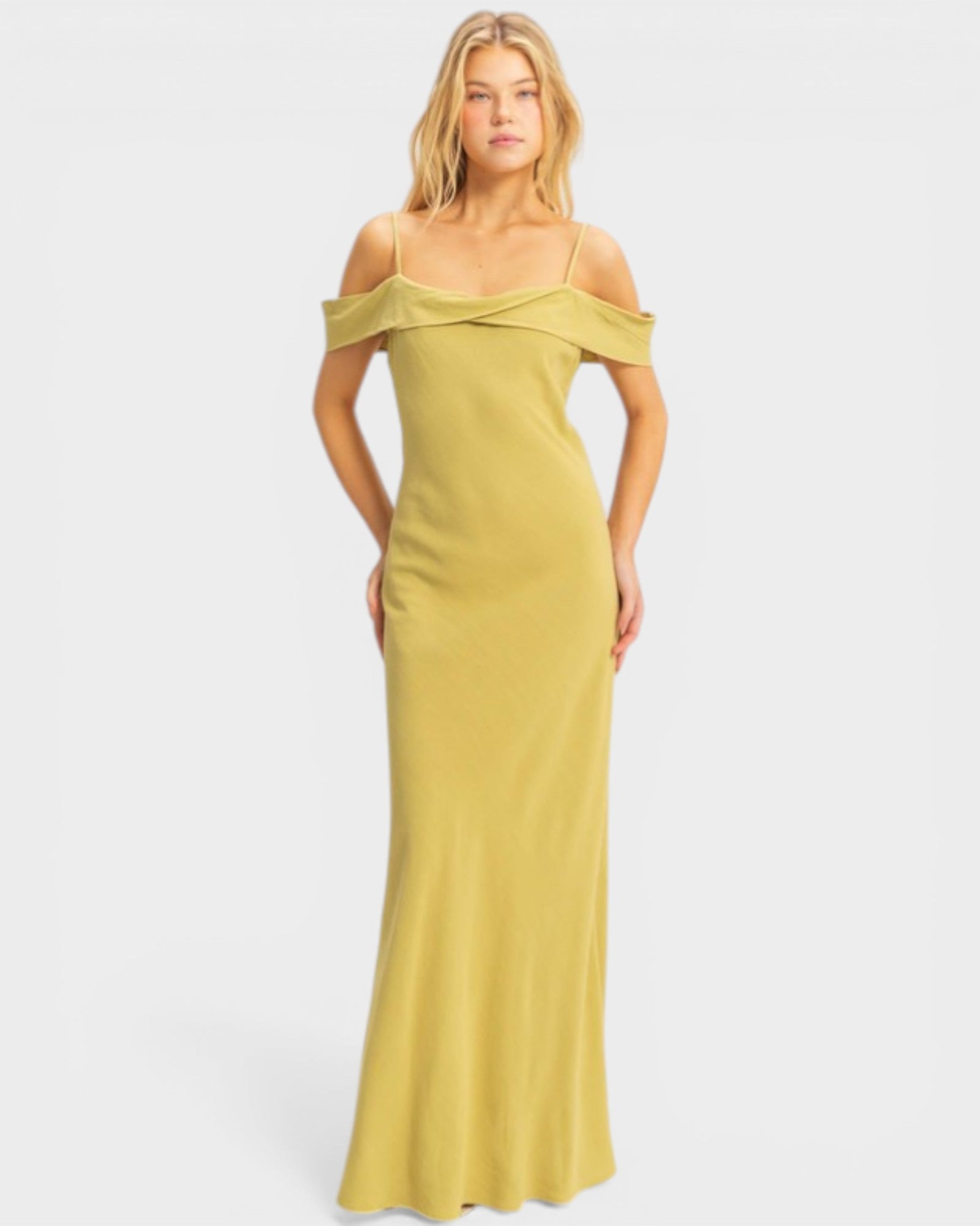 Woman wearing a yellow off-shoulder gown on a white background