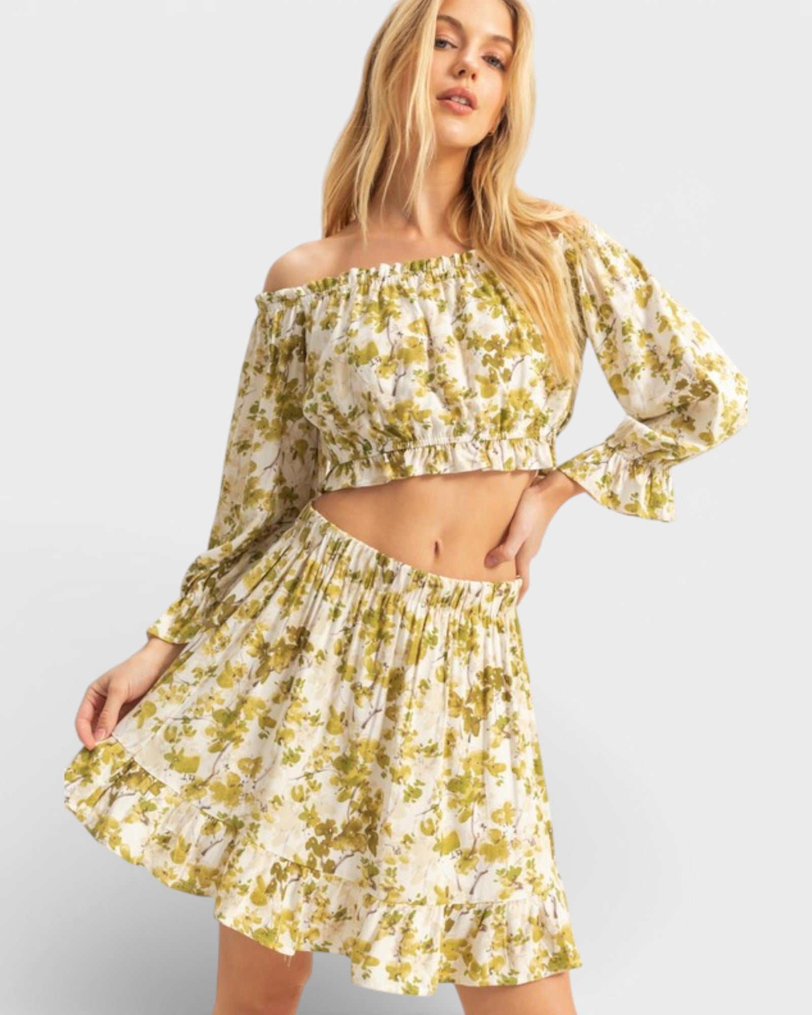 Woman wearing a floral off-shoulder dress on a plain background