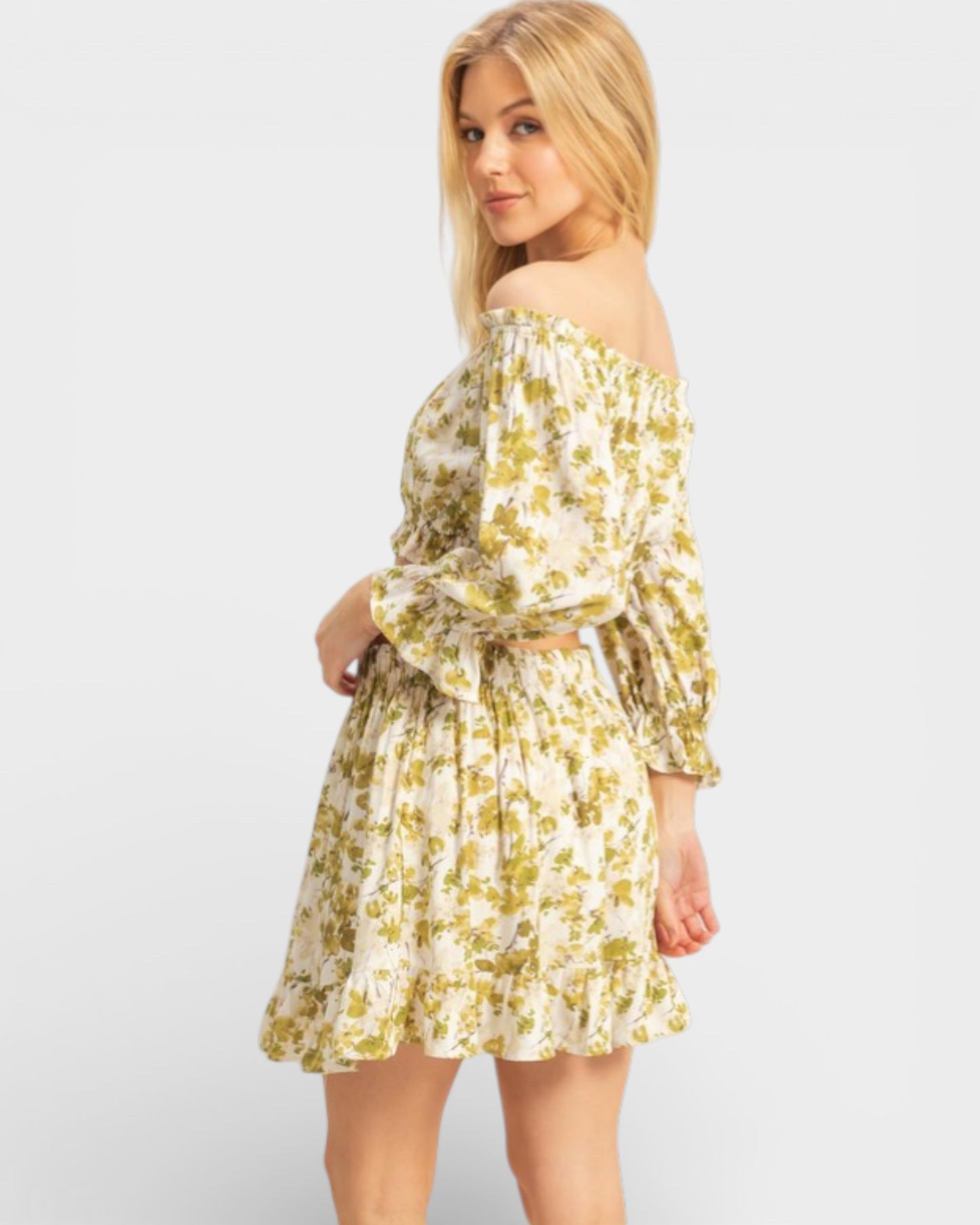 Woman wearing a yellow floral off-shoulder dress on a white background