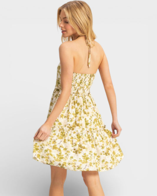 Woman wearing a yellow floral dress on a white background
