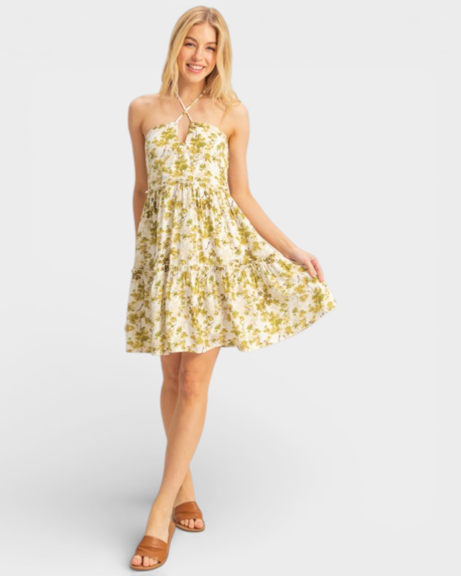 Woman wearing a yellow floral dress on a white background