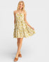 Woman wearing a yellow floral dress on a white background