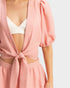 Pink cover-up with cut-out design over a white background