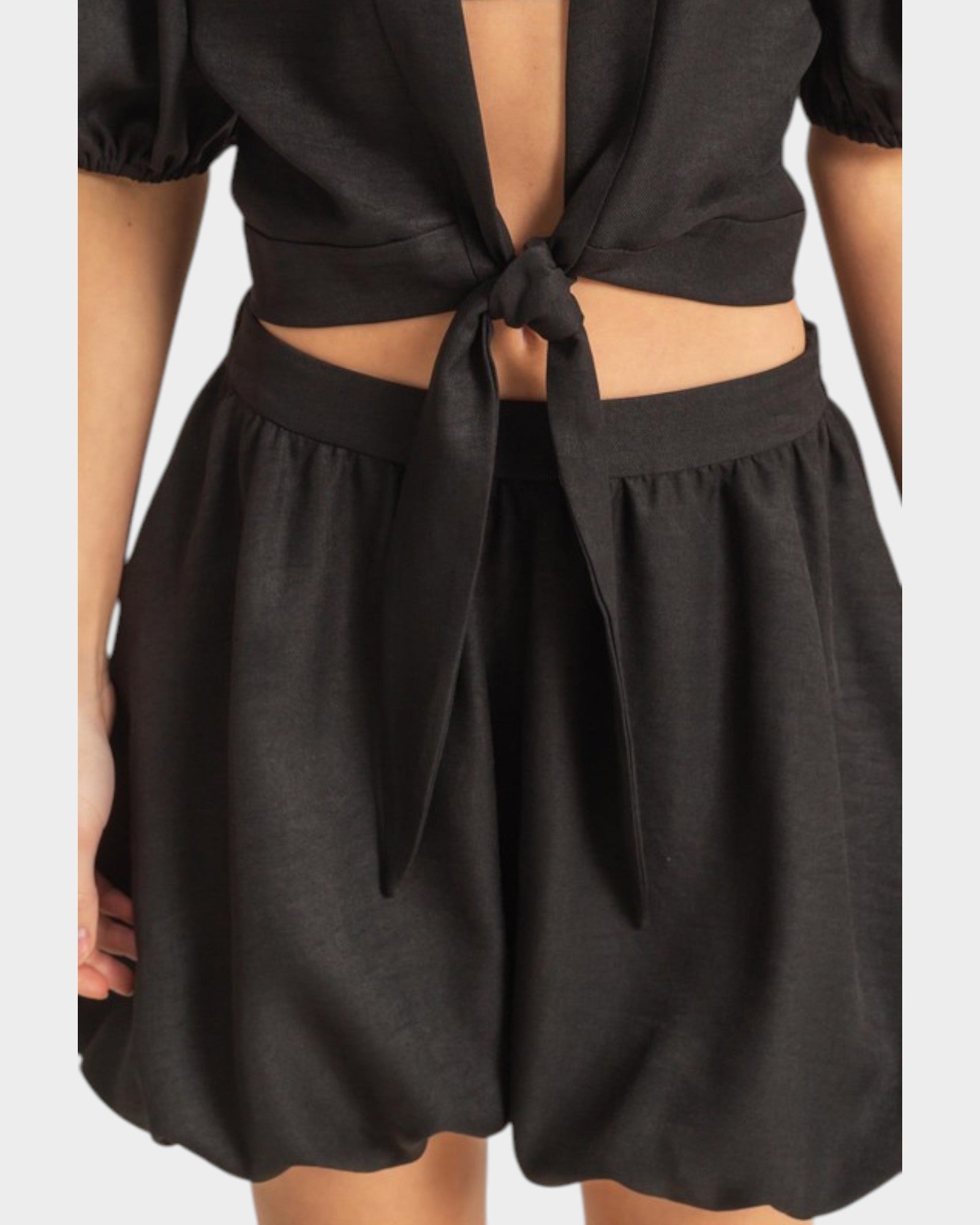 Black outfit with open front design on a white background