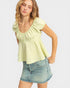 Woman wearing a light green top and denim skirt on a white background