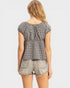 Woman wearing a black and white checkered top and light denim shorts on a white background