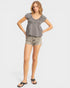 Woman wearing a checkered top and denim shorts on a white background
