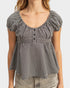 Black and white checkered peplum top worn by a person on a plain background