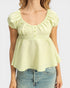 Light green blouse with ruffled sleeves worn by a person on a white background