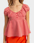 Red and white checkered top worn by a person on a plain background