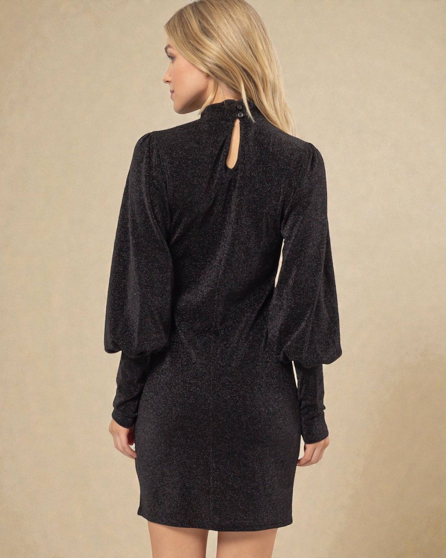 Woman wearing a dark gray dress against a beige background