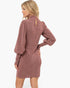 A woman modeling a dusty rose textured knit dress with balloon sleeves, shown from a three-quarter back angle against a plain white background.