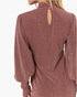 A close-up back view of a woman wearing a dusty rose long-sleeve top with a high neck, three back buttons, and a small keyhole cutout at the top. The fabric has a subtle textured sheen.