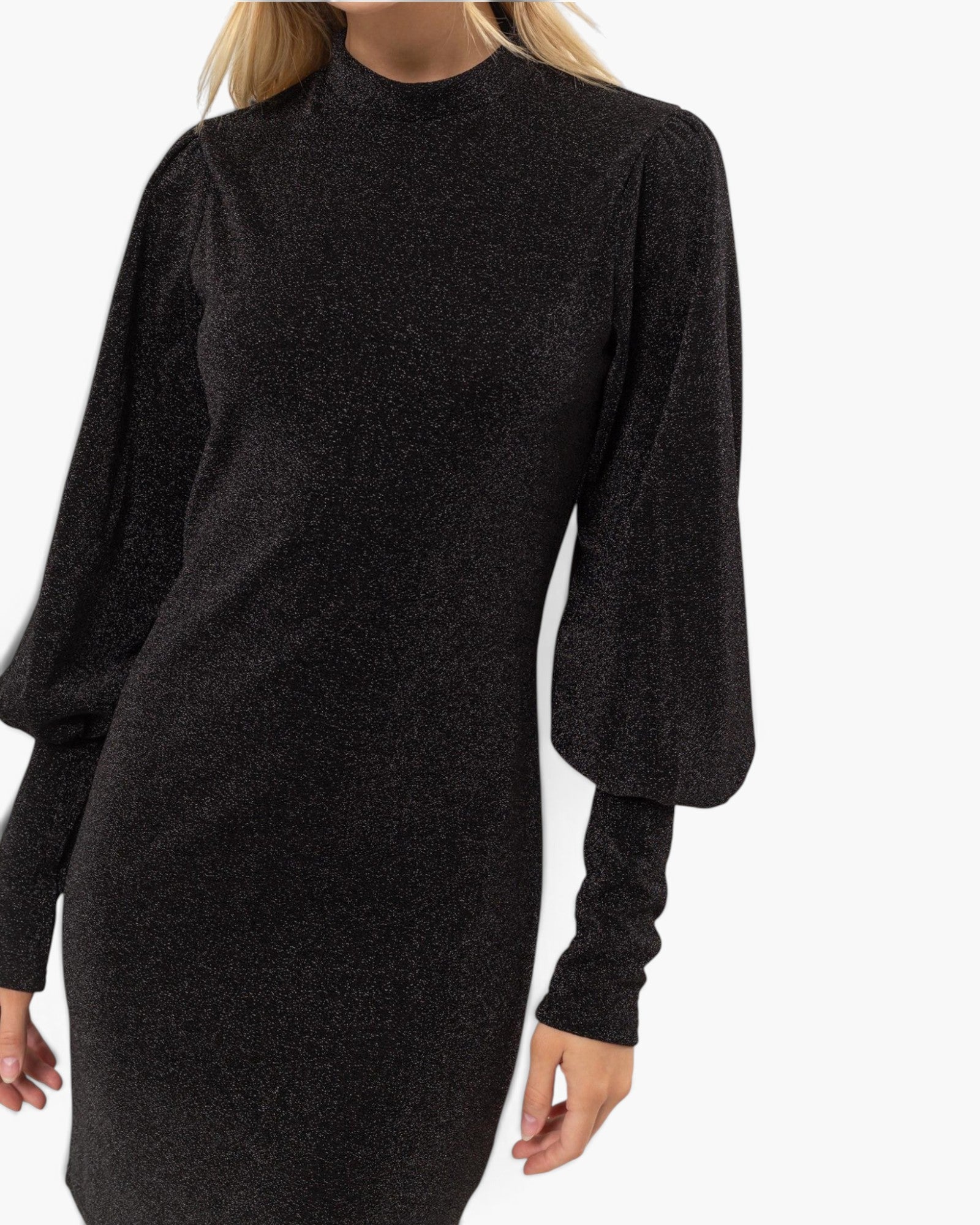 A woman wearing a black long-sleeve knit dress with a high mock neck and voluminous balloon sleeves, shown against a plain white background.