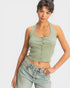 Woman wearing a green halter top and blue jeans on a white background