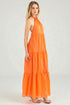 Woman wearing an orange halter neck dress on a white background
