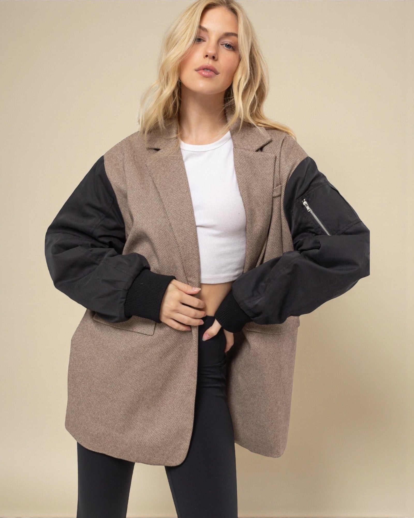 Woman wearing a brown and black jacket with a plain background