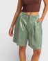 Person wearing green shorts and a brown top on a white background