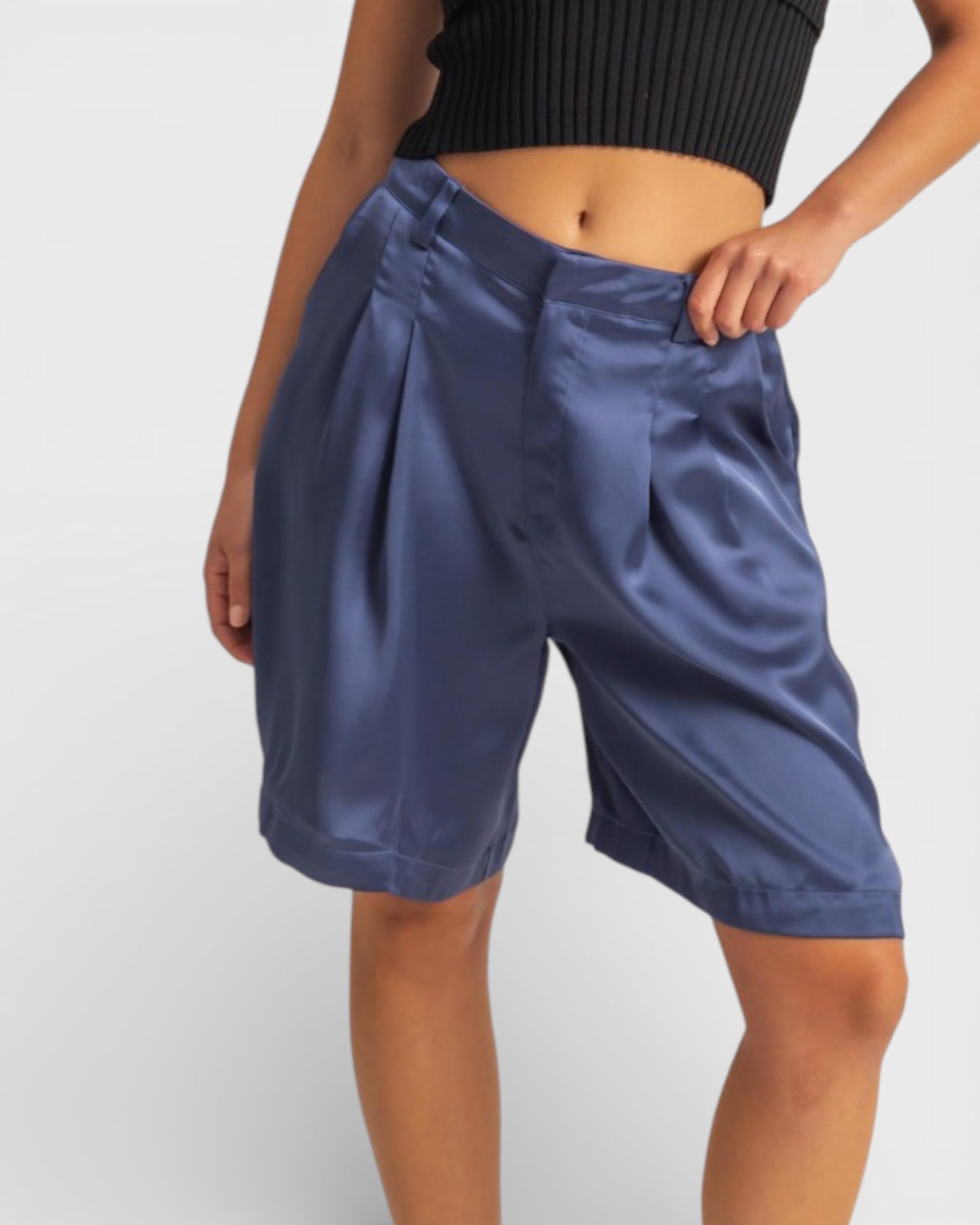 Blue satin shorts worn by a person on a white background
