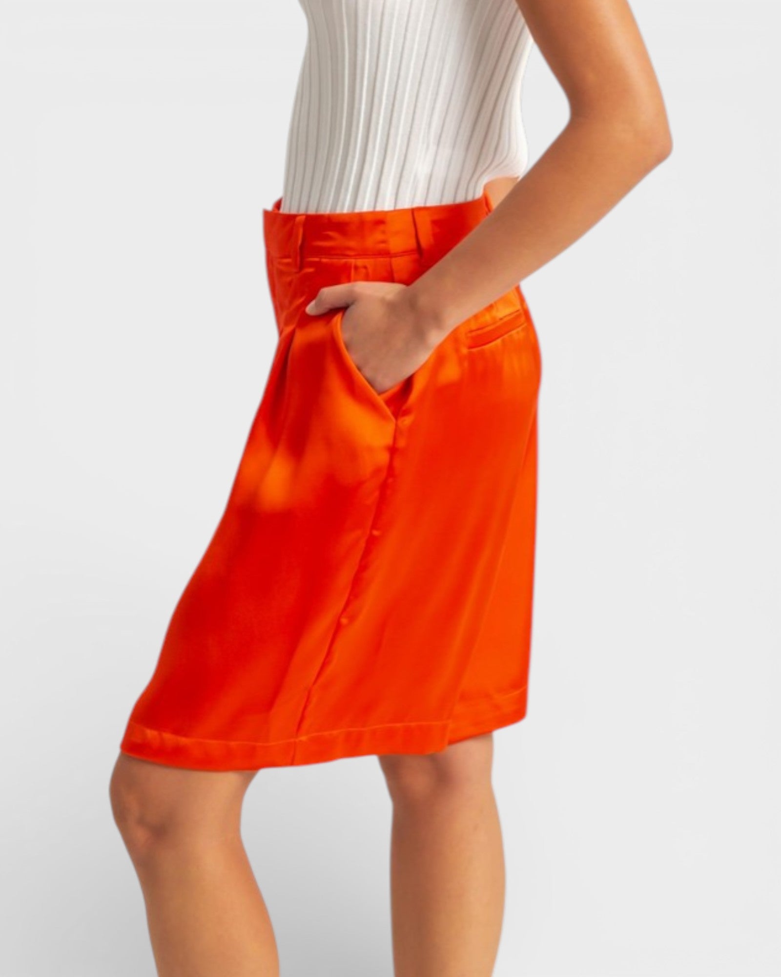 Orange skirt worn by a person on a plain background