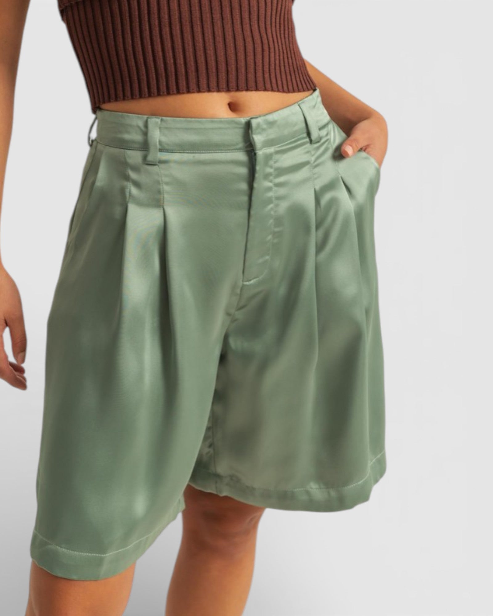 Person wearing green shorts on a plain background
